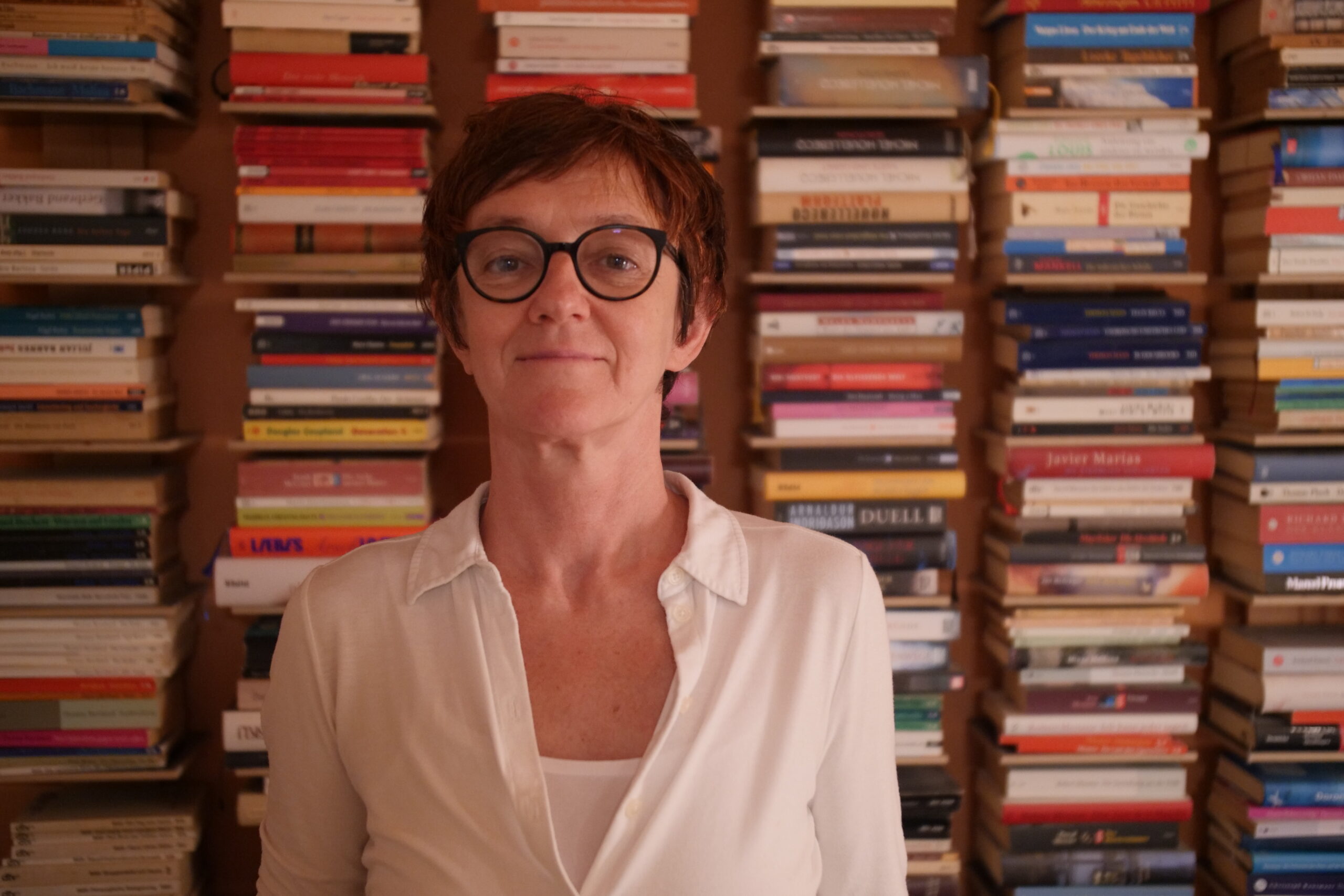 Elli Scambor steht vor einer Bücherwand.